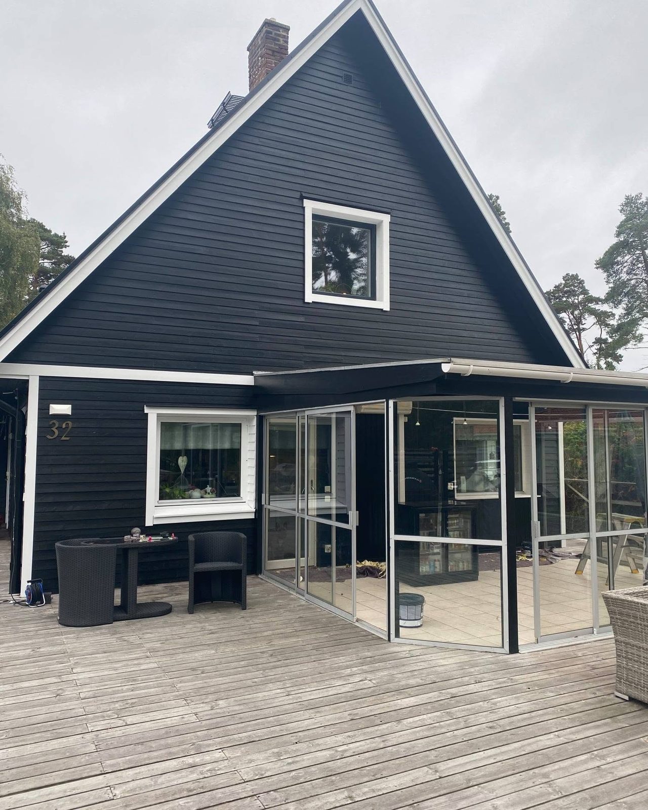 Svart villa med spetsig gavel och inglasad altan