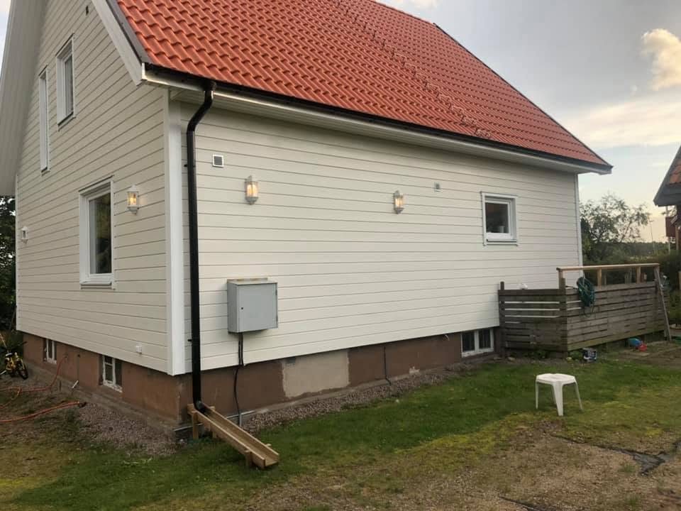 Vit villa med rött tak i kvällsljus
