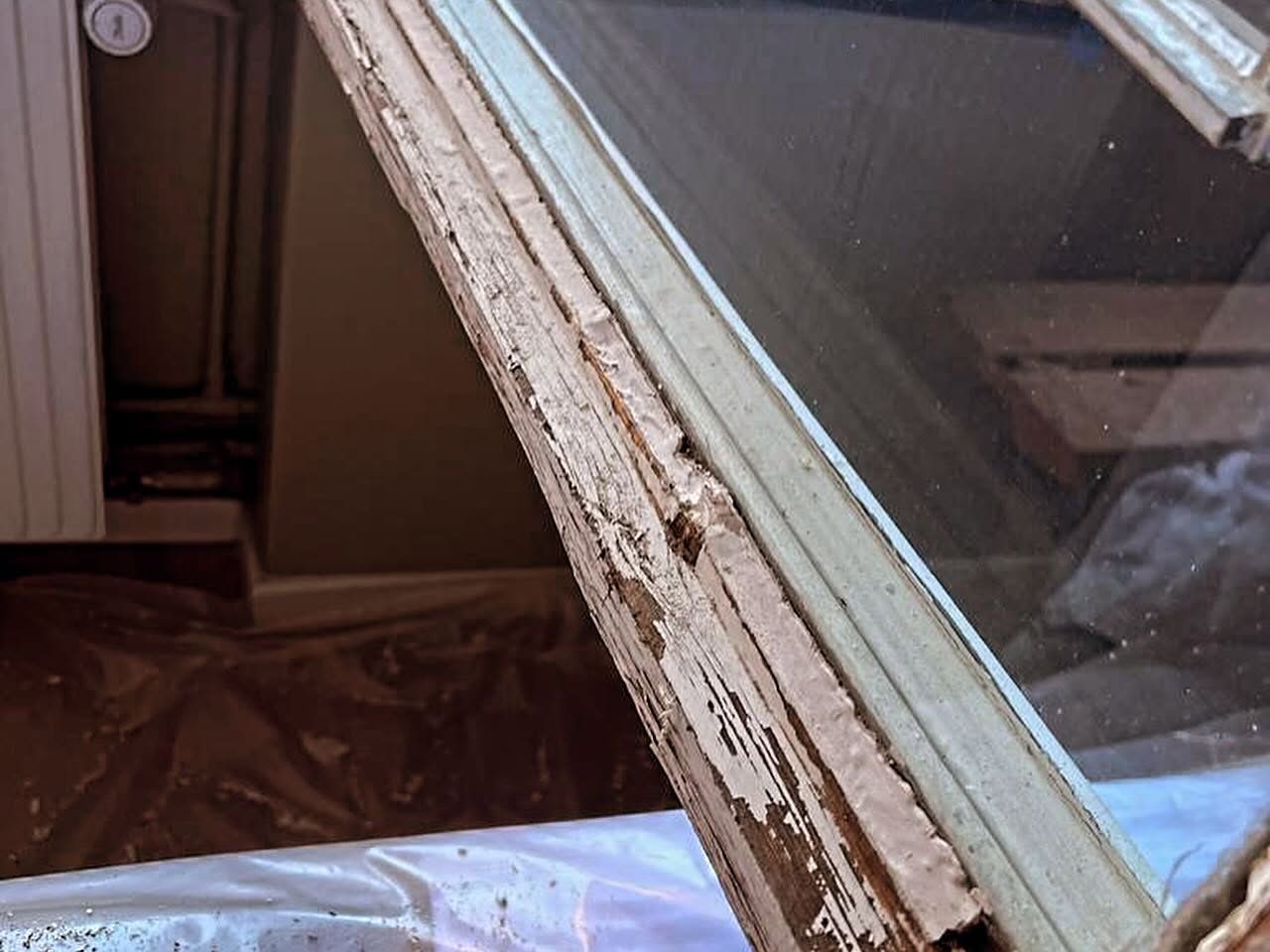 Fönsterkarm med flagnande färg före renovering