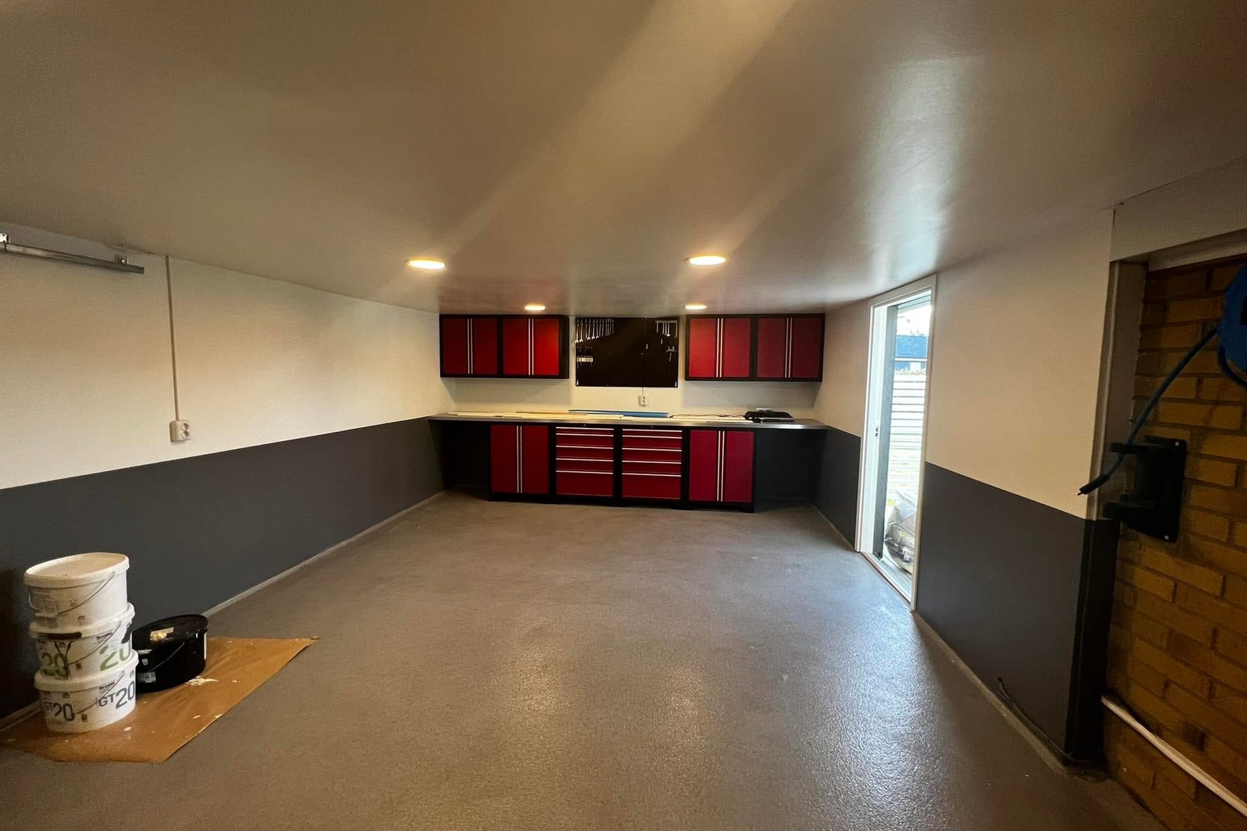 Garage med nymålade väggar och golv samt röda verktygsskåp