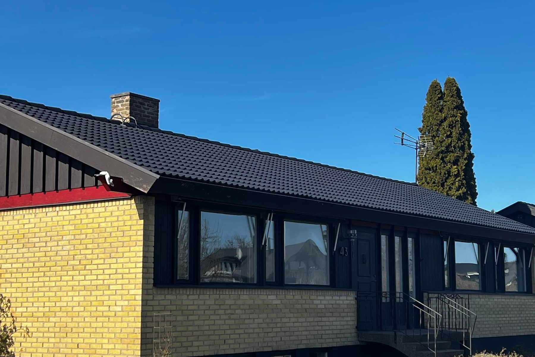 Villa i gult tegel med svart tak